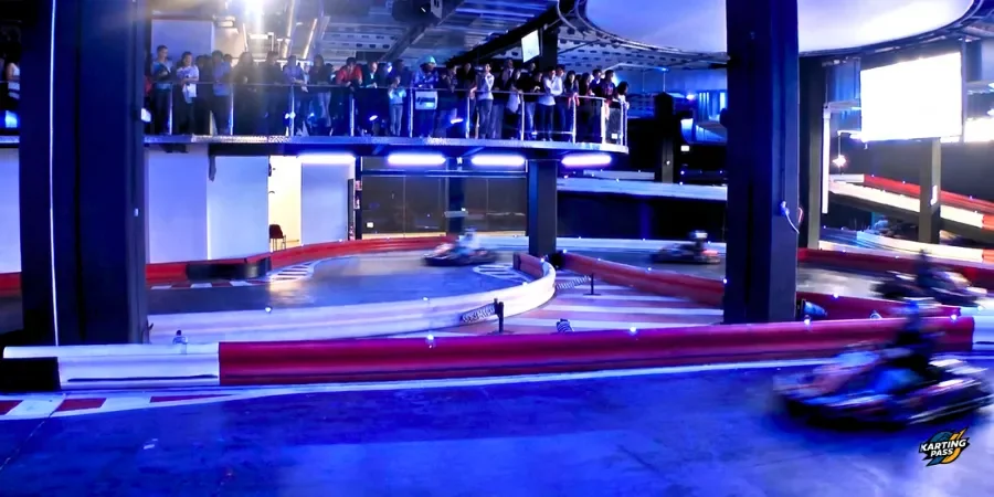 Carrera en el circuito indoor de Karting Marineda Coruña con público en graderío.